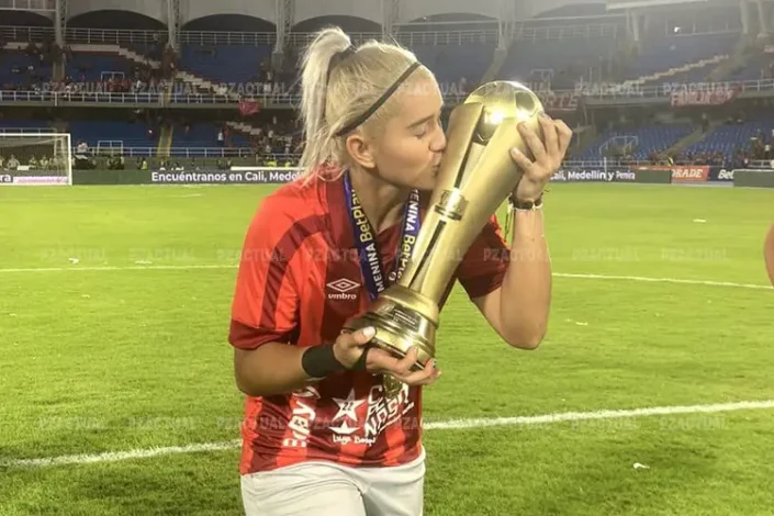 Sharon Corrales besando una copa de campeonas